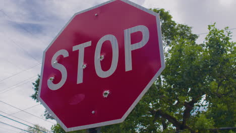 A-stop-sign-full-of-bullet-holes,-in-Youngstown-Ohio,-welcome-home,-stop-violence