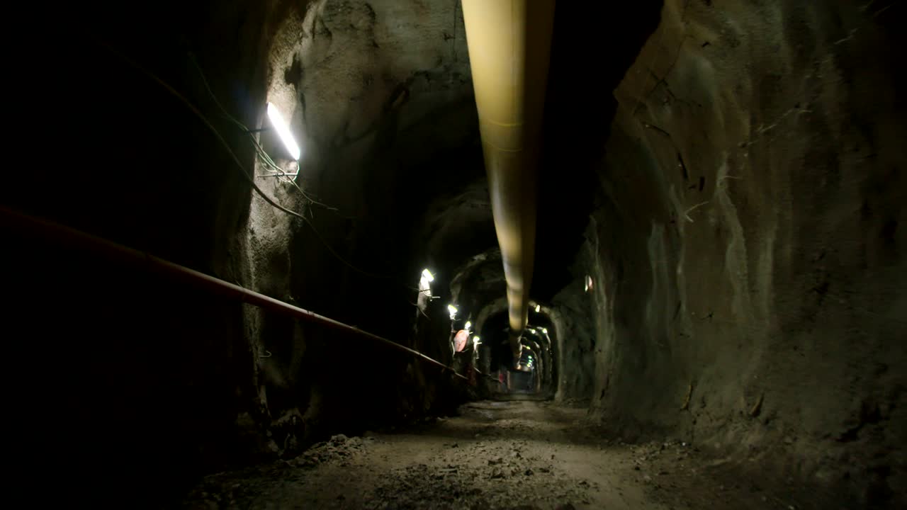 pov caminando disparado dentro de un gran túnel de construcción oscuro