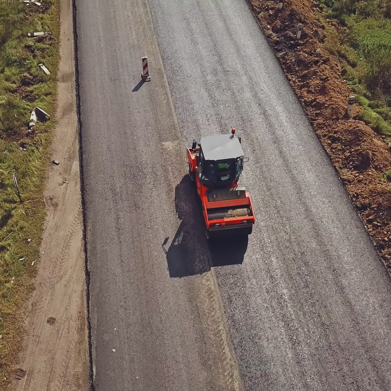 Aerial view on the road roller working on the new road construction site. Repair of the road in the city