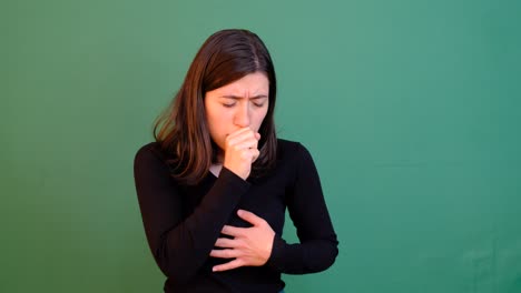 woman coughing green background