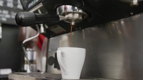 close up of working coffee machine pouring fresh coffee into cup at cafe