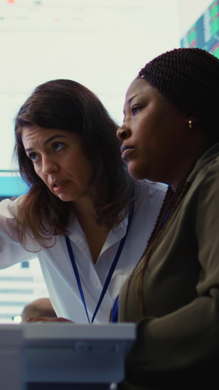 Two Diverse Businesswomen Discussing Data and Charts in Office