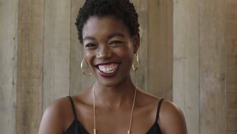 portrait-of-young-independent-african-american-woman-laughing-happy-looking-at-camera-wooden-background