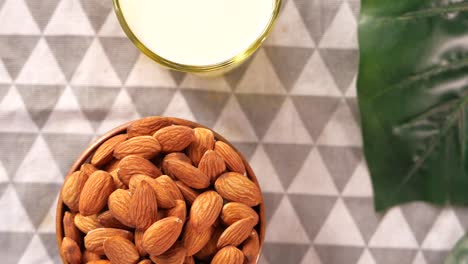 almonds in a bowl with a glass of milk