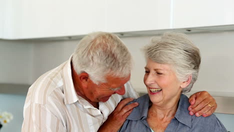una pareja de mayores sonriendo a la cámara juntos