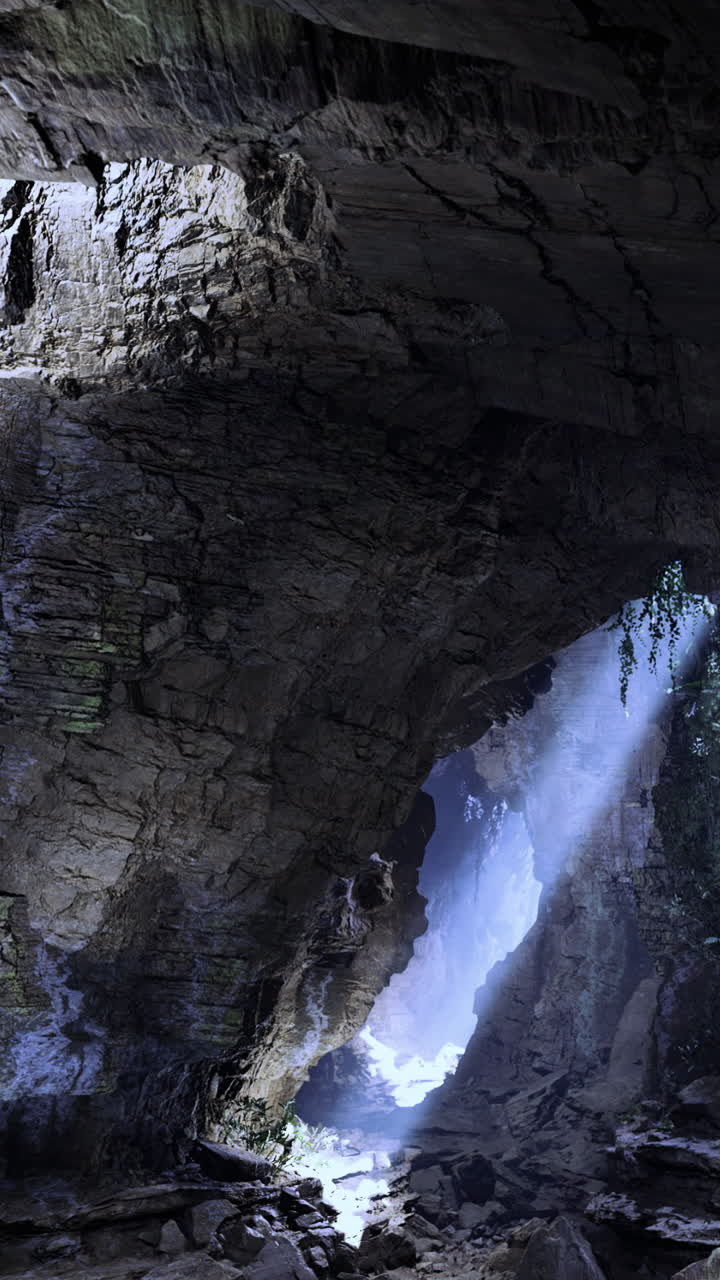 Cascata e luce che filtra attraverso una grotta nella natura a mezzogiorno.