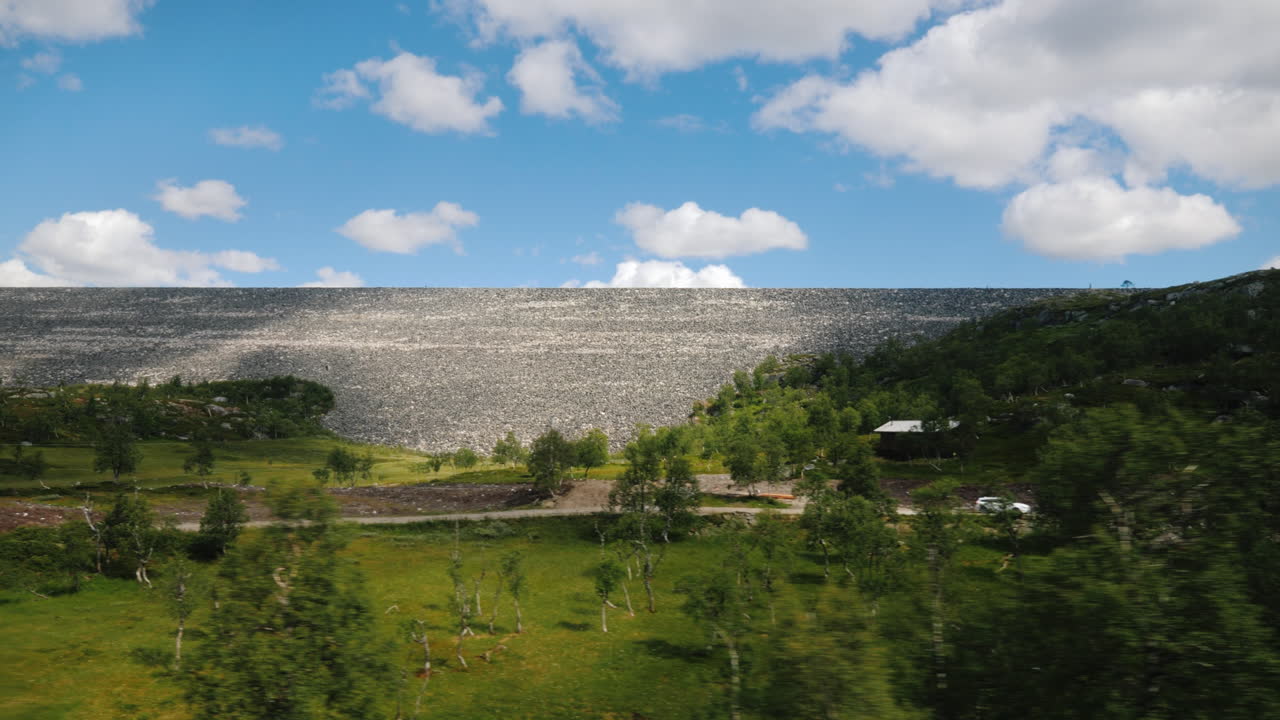 вид из окна автомобиля на пейзаж в норвегии с большой каменной плотиной