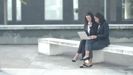 confident secretary showing project to boss on laptop and typing