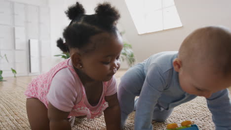 Baby-Boy-And-Girl-Playing-With-Toys-On-Rug-At-Home-Together