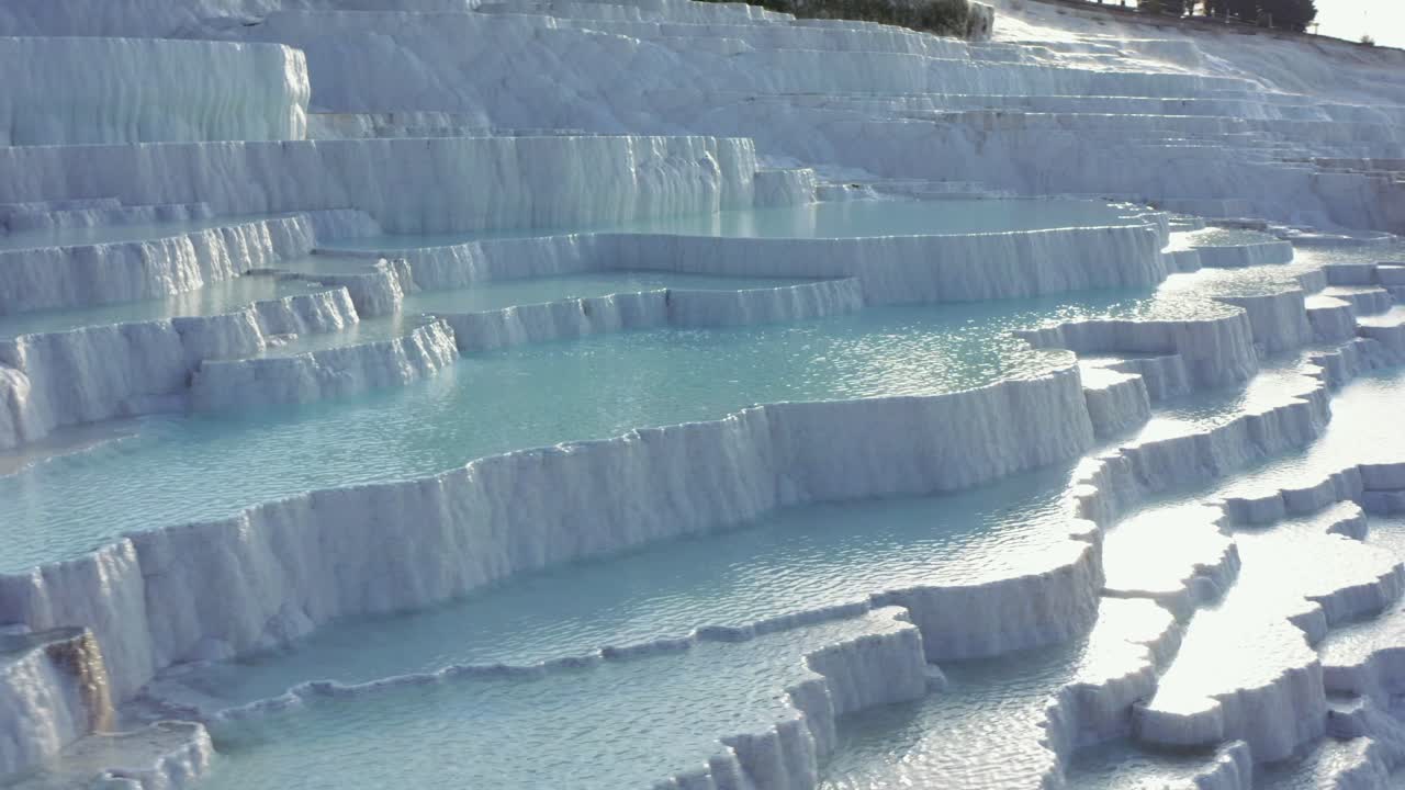 White travertine terraces or travertine pools that cascade down the hillside in Pamukkale