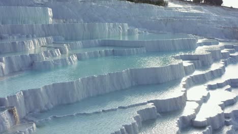 terrazas de travertino blanco o piscinas de travertino que caen en cascada por la ladera en pamukkale