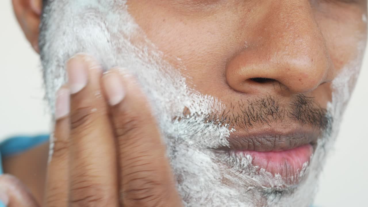 primer plano de un hombre afeitándose la cara