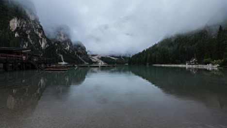 Moody-foggy-day-in-Dolomites,-reflection-on-calm-lake-water,-time-lapse