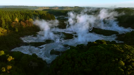 Wide angle of sunrise, Drone slowly flying over geothermal landscape. Trees, steam, bubbling mud and steam. Alien Landscape. Sci-fi. Global Warming