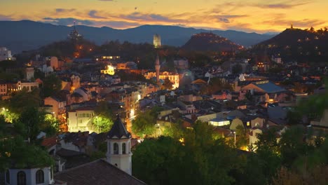 vista nocturna de la ciudad vieja de plovdiv, bulgaria. viejas casas iluminadas y cielo al atardecer. zoom shot. vista desde la colina de nebet tepe plovdiv canter ciudad. 4k