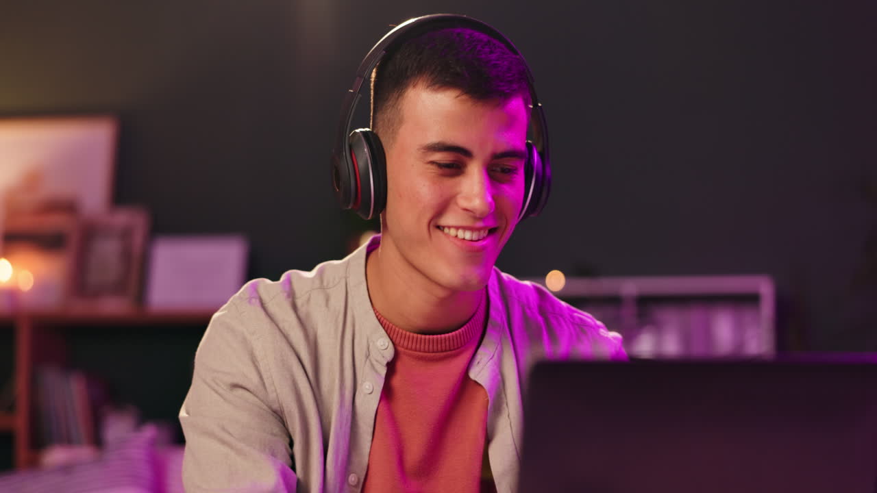 Man wearing headphones using a laptop