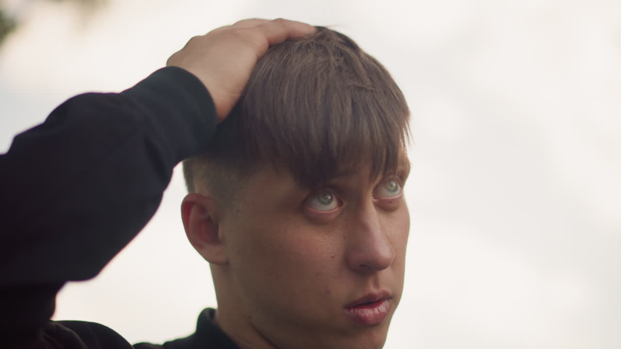 자신감 넘치는 모습으로 머리를 스타일링하는 도시 남성, 도시 풍경 속에서 자신의 헤어스타일을 자신 있게 정리하는 패셔너블한 개인, 도시 환경 속에서 자신의 머리를 자신감 있게 스타일링하며 상황을 주도하는 패셔너블한 남성