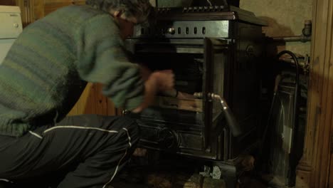 joven preparando fuego cargándolo con palos antes de encenderlo