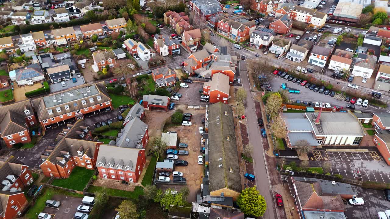Droneoptagelse af landskabet, der panorerer over Locks Heath-området i Hampshire, Sydengland. En lille landsby nær Southampton med en smuk gylden solnedgang ovenover og små forstadshuse nedenfor
