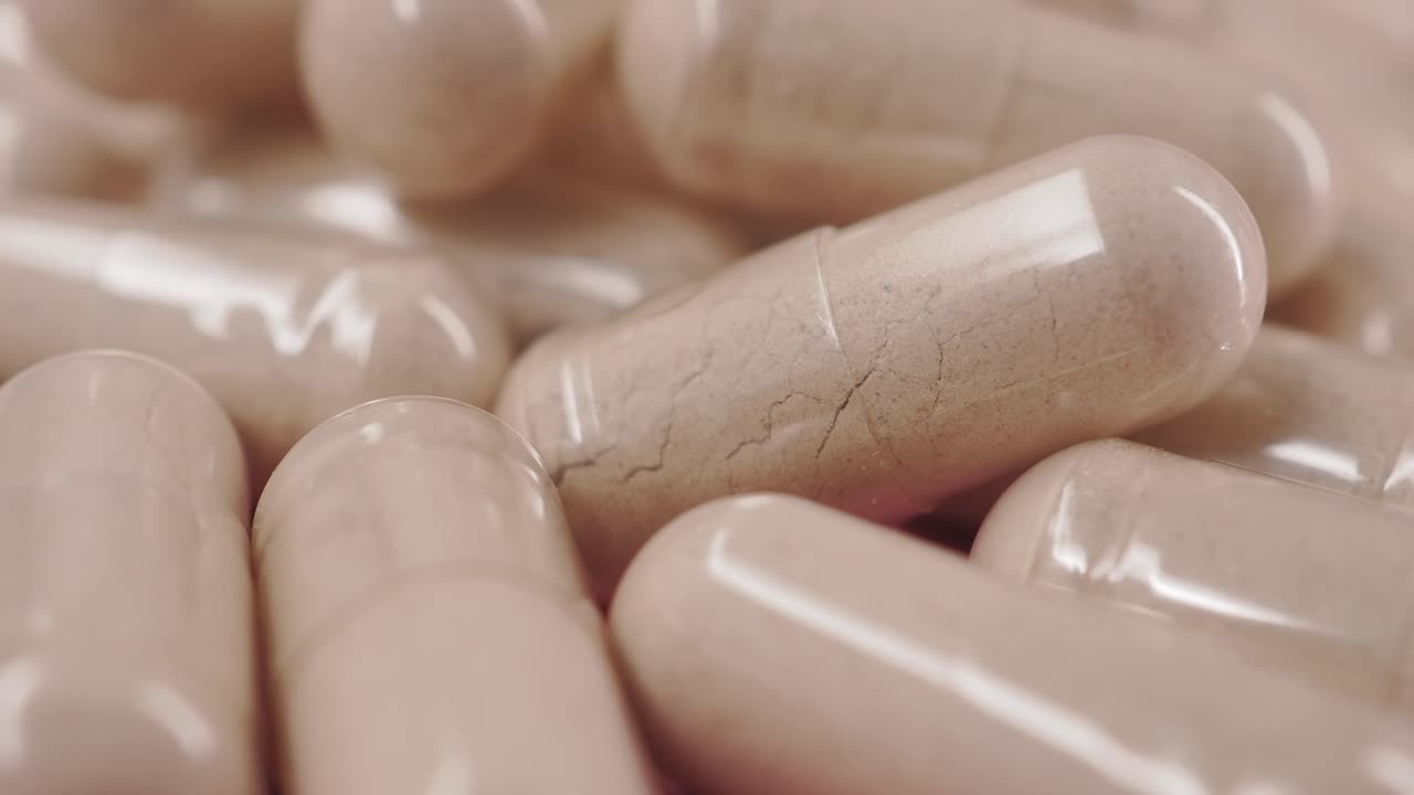 Primo piano di capsule traslucide riempite di polvere.
