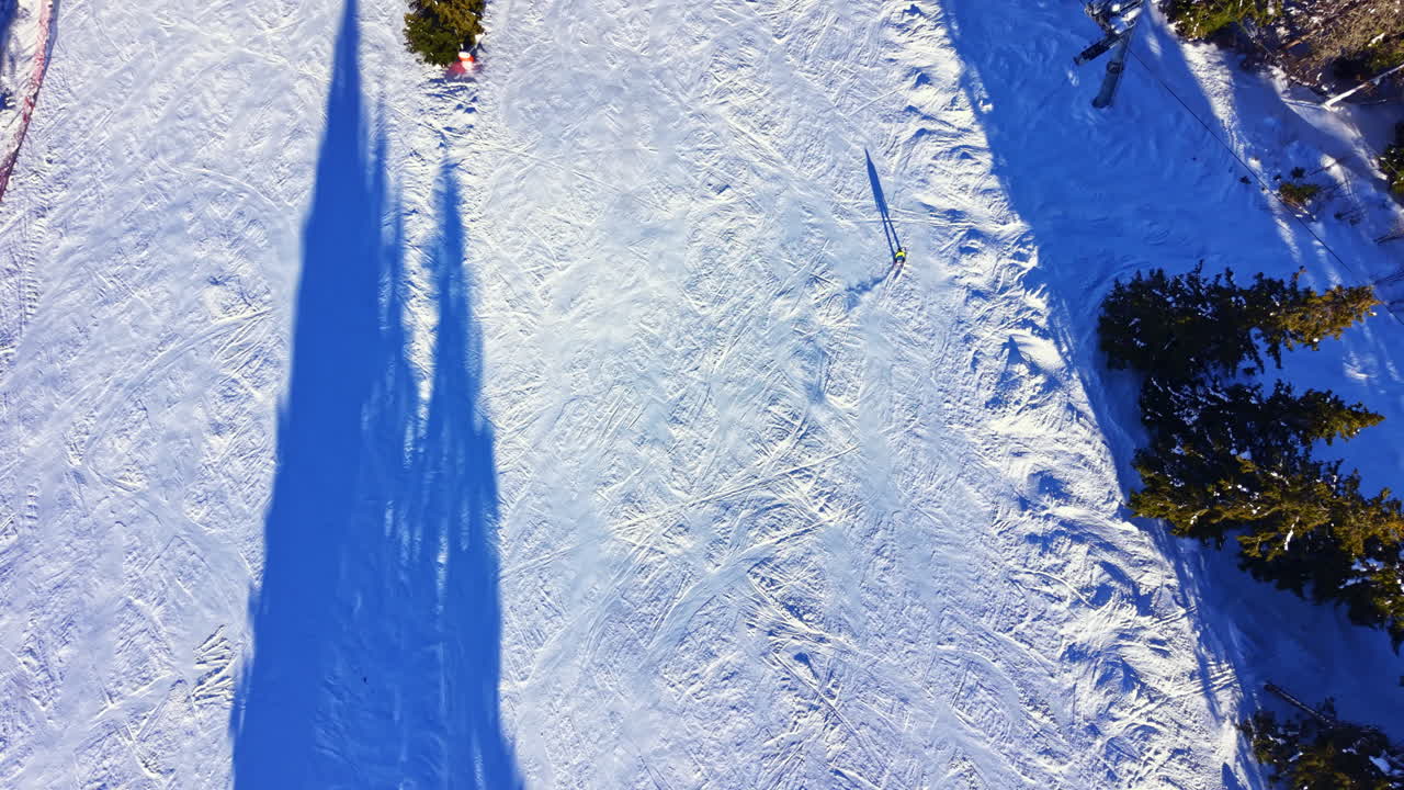 Aerial View of Skier Carving Down a Snowy Mountain Slope