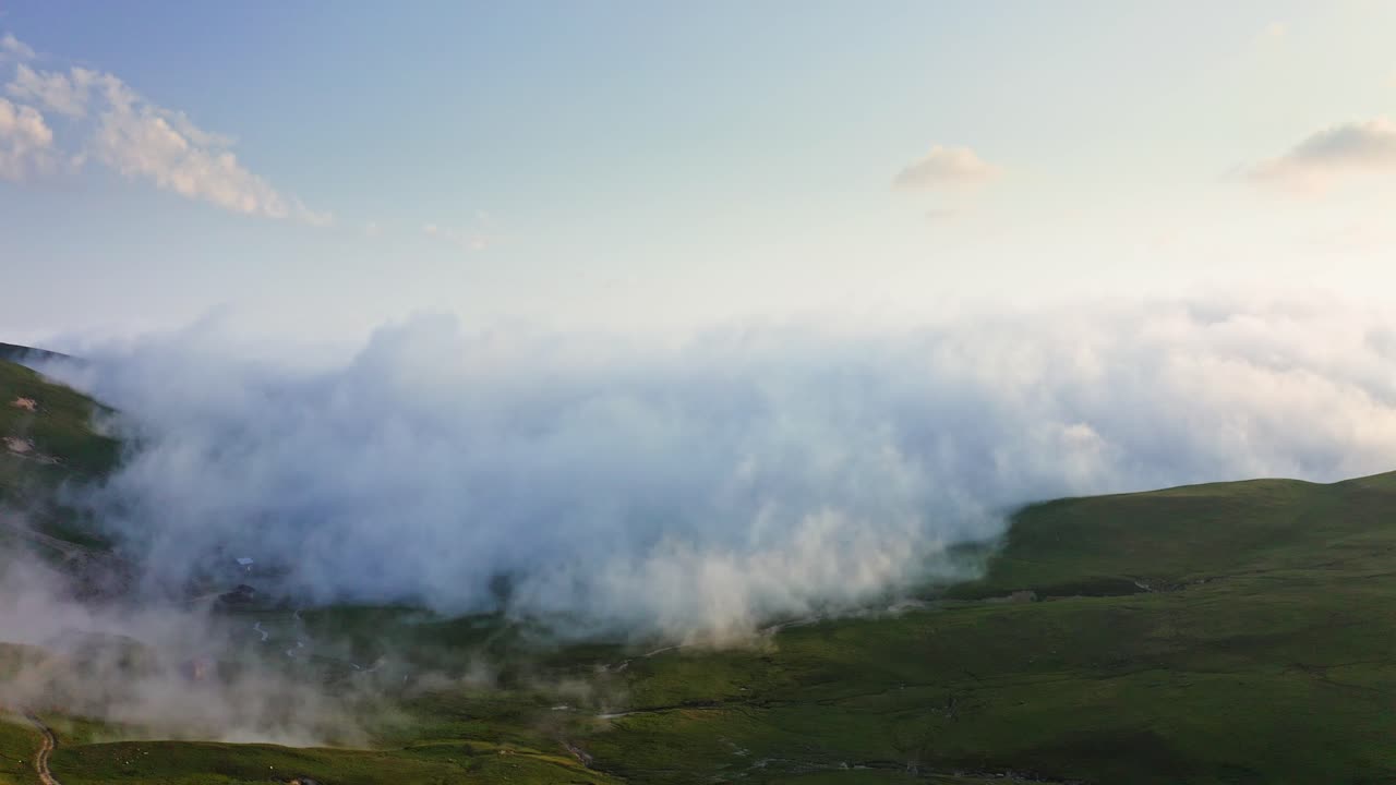 niebla densa y nubes que se arrastran sobre la meseta montañosa al atardecer