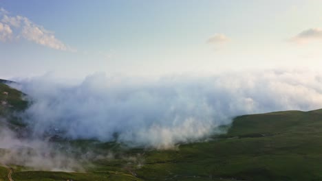 dense fog and cloud creeping over mountain plateau at sunset