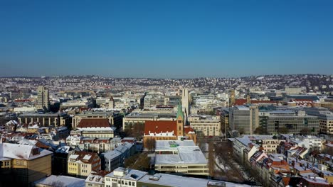 vuelo aéreo a través del hermoso centro de la ciudad con techos de tejas rojas, calles y montañas cubiertas de nieve durante el invierno en leonhardsviertel stuttgart, alemania