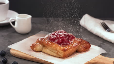 super slow motion tilt down shot of powdered sugar being sprinkled on a pastry cake. shot with high speed camera at 420 fps