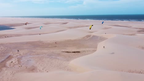 Grupo-De-Kitesurfistas-Caminando-Sobre-Un-Enorme-Banco-De-Arena-En-Brasil-Junto-Al-Mar