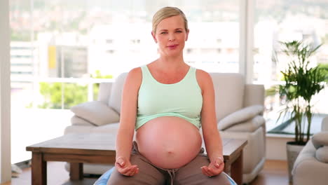 pregnant woman sitting on blue exercise ball