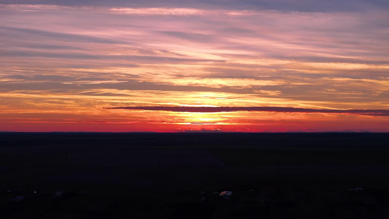 검은색과 오렌지색으로 묘한 마을 위에 매혹적인 해가 지는 모습