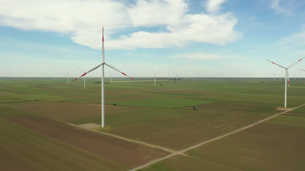 View on several windmills, wind generators, turbines, producing renewable clean energy by converting kinetic energy
