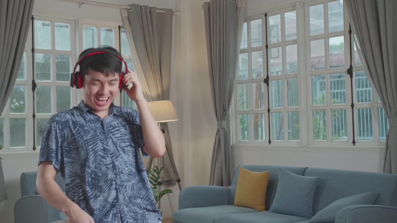 ชายหนุ่มร่าเริงกำลังทำความสะอาดบ้านและร้องเพลง เขากำลังใช้เครื่องดูดฝุ่นเป็นกีตาร์และไมโครโฟน