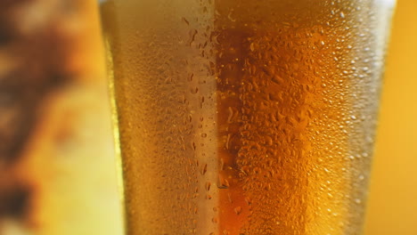 Macro-Shot-Of-Fine-Bubbles-Rising-In-A-Glass-With-Orange-Liquid