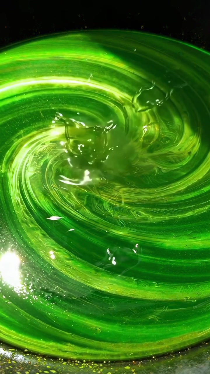 Líquido Verde Vibrante Girando com Gotas Salpicando