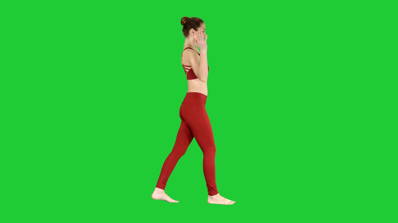 Young woman practicing breathing exercise and walking on a Green Screen, Chroma Key