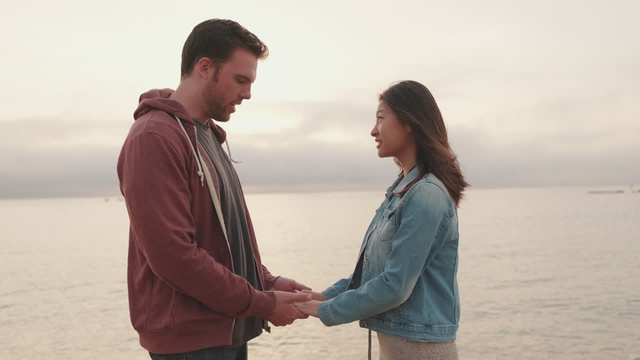 Una pareja de manos en la playa.