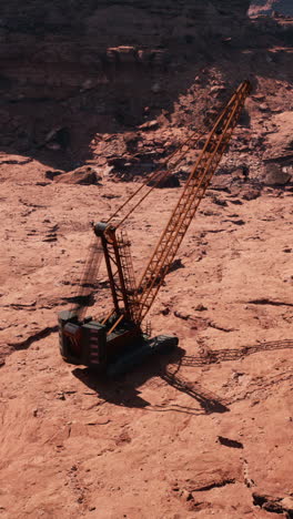 a large crane sits in a red desert canyon