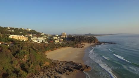Aerial-drone-shot-over-the-coastline-towards-the-community-of-Coolum