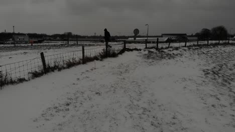 man skips over the fence during cold weather in winter. wide shot