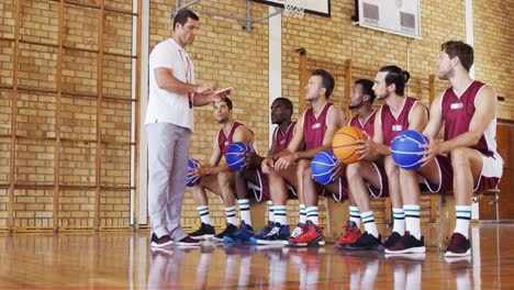 entrenador de baloncesto ayudando a los jugadores en una tableta digital