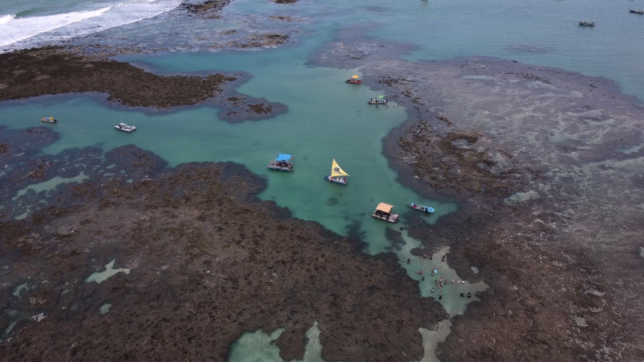 turistas y barcos en piscinas naturales con arrecifes de coral