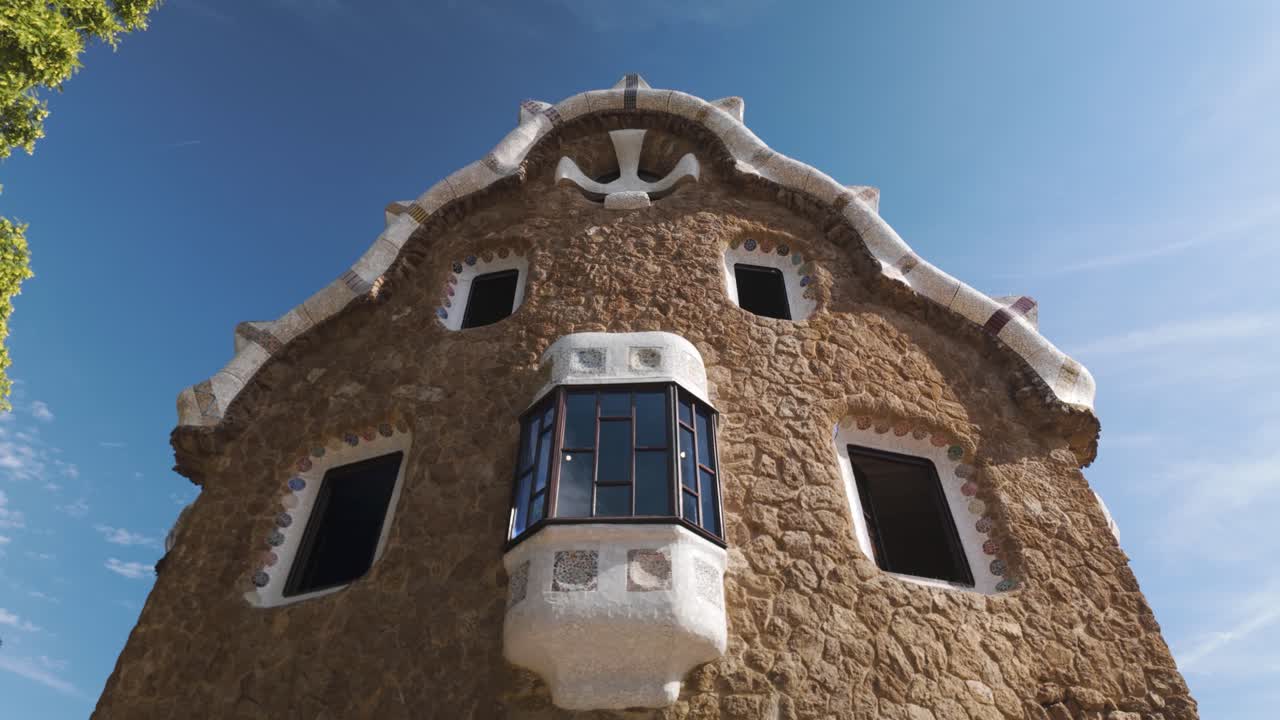 A close-up view of the Porter Lodge Pavilion showcasing its intricate architecture and organic design features in beautiful Park Güell, a famous landmark located in Barcelona, Spain.