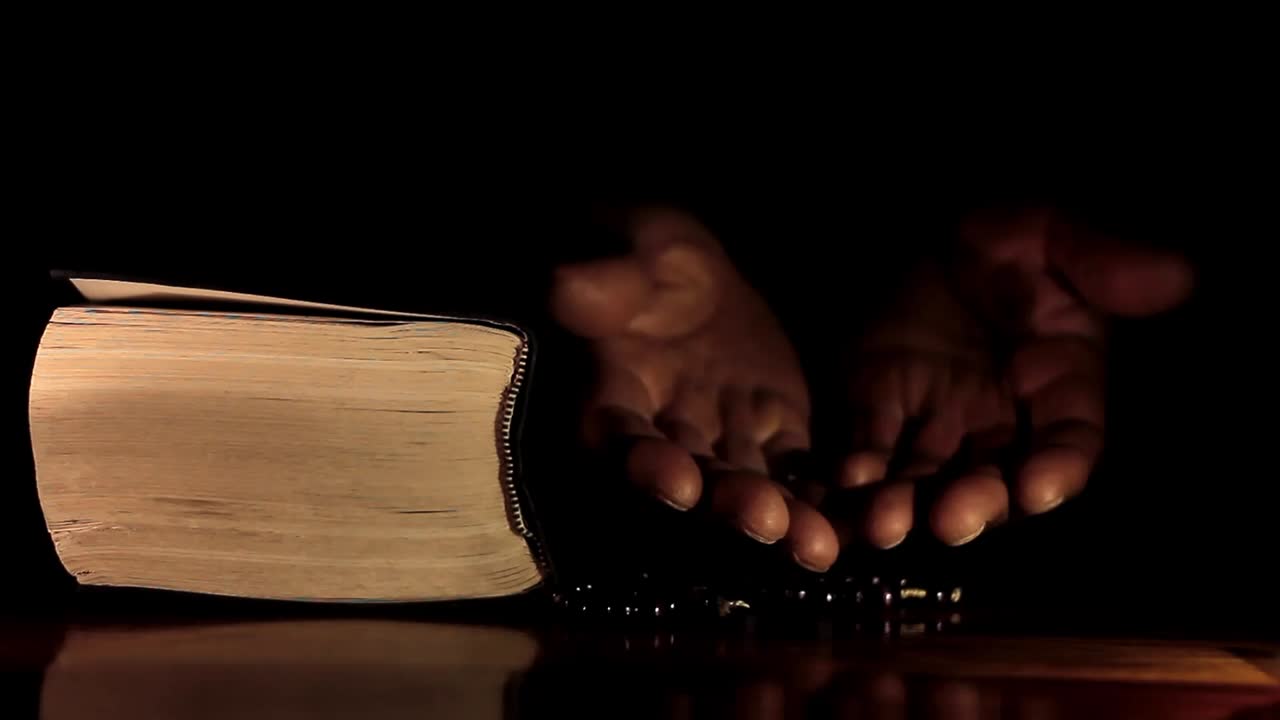 성경과 함께 손으로 신에게 기도하는 남자 검은 배경으로 기도하는 캐리비안 남자 스톡 비디오