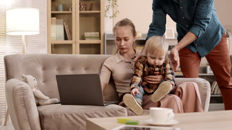 man taking child from working woman