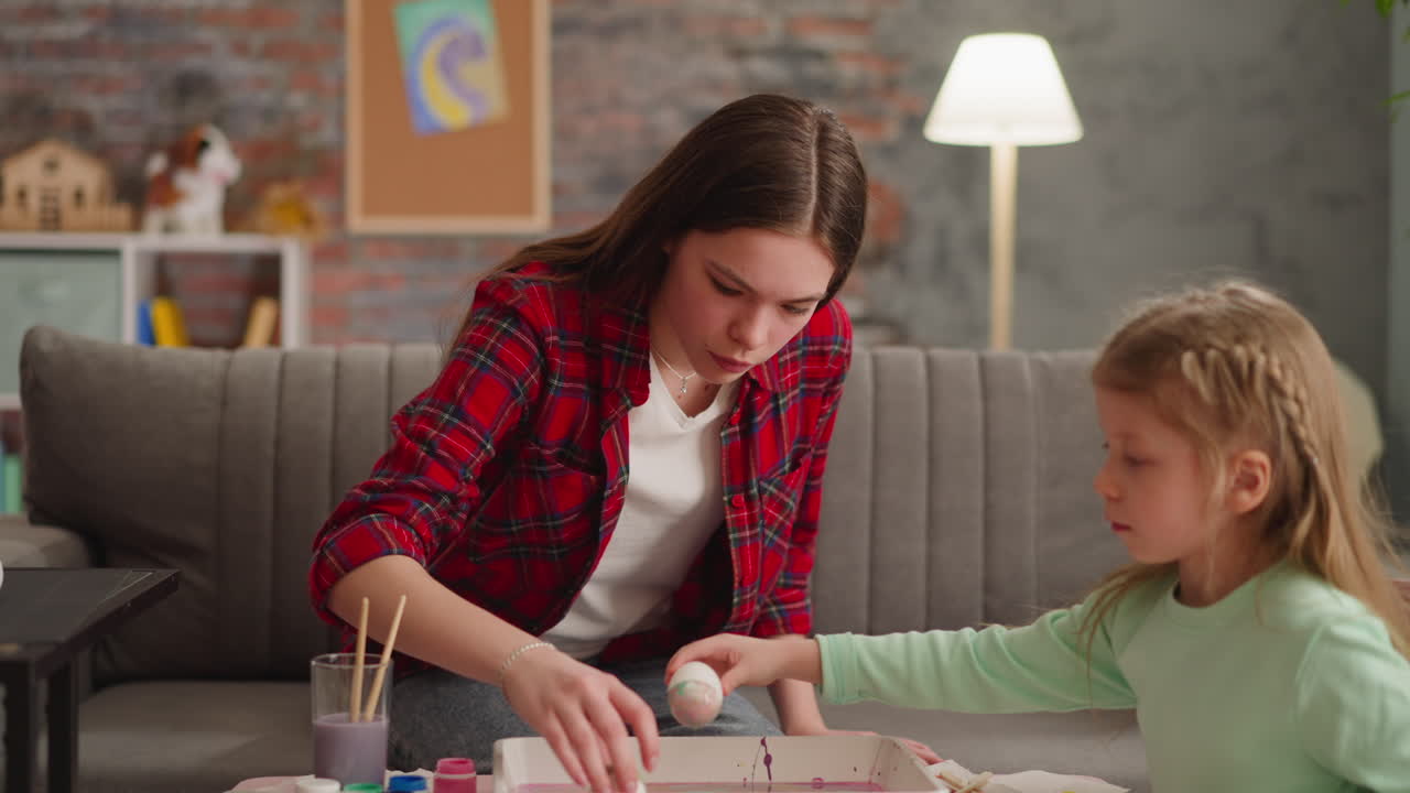 adolescente y niña color y mirar a los huevos de decoración ebru