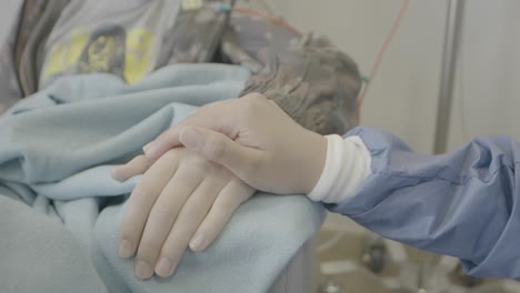 a person in the hospital receiving hand touches and support from family members