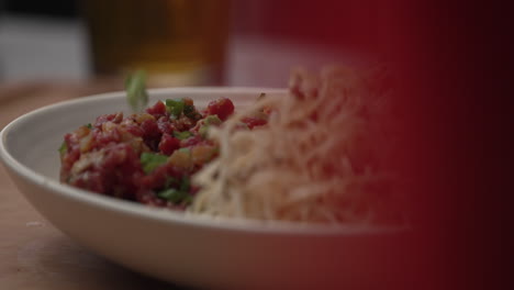 Macro-Of-Sprinkling-Sliced-Green-Onions-Into-Beef-Tartare