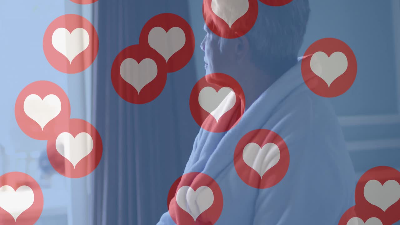 배경에 침대에 앉아 있는 고령 여성 위에 심장 사랑 아이콘의 애니메이션